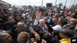 Rached Ghannouchi, the leader of Tunisia's Islamist movement Ennahdha, waves upon arrival in Tunis after 22 years in exile on January 30, 2011