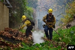 Petugas pemadam kebakaran bekerja untuk memadamkan api di kawasan Mandeville Canyon di Los Angeles, California, pada 11 Januari 2025, saat Kebakaran Palisades terus berkobar. (Foto: AFP)