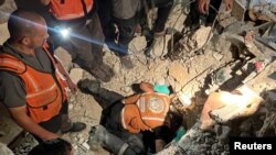 FILE -Palestinian rescuers search for casualties under the rubble of a house hit by an Israeli strike, in Gaza City, November 7, 2023.