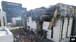 Los bomberos llevan un cuerpo en el lugar de un incendio en una fábrica de baterías de litio en Hwaseong, Corea del Sur, el lunes 24 de junio de 2024.