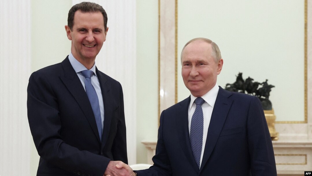 In this pool photograph distributed by the Russian state agency Sputnik on July 25, 2024, Russia's President Vladimir Putin, right, shakes hands with Syria's President Bashar al-Assad during their meeting at the Kremlin in Moscow on July 24, 2024.