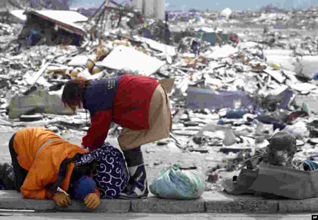 Survivors react after collecting their belongings at their destroyed house in a village hit by an earthquake and tsunami in Otsuchi. (Reuters Image)