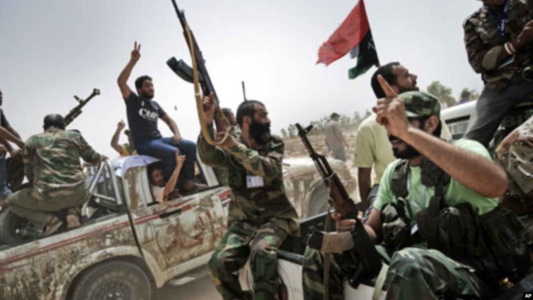 Libyan rebel fighters shoot in the air and shout religious slogans as they attend the funeral of 7 fallen comrades killed the day before during the battle for the control of the oil rich town of Brega at the main cemetery in the Libyan rebels stronghold c