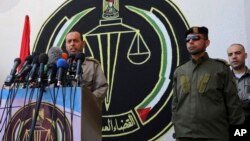 FILE - Nasser Suliman, head of military judiciary, announces during a press conference that the military court sentenced to death three men convicted of killing Mazen Faqha, a top militant commander in March, at Hamas military judiciary building in Gaza City, May 21, 2017. 
