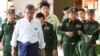 FILE - Rakhine Chief Minister Nyi Pu, left, and Myanmar's high ranking military officers walk after a daytrip with a diplomatic mission and United Nations officials to the Maungdaw area in northern Rakhine State in Myanmar, Nov. 3, 2016.