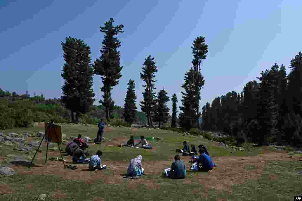 طلبہ سماجی فاصلے قائم رکھتے ہوئے دائرے کی شکل میں بیٹھ کر کلاس لے رہے ہیں۔