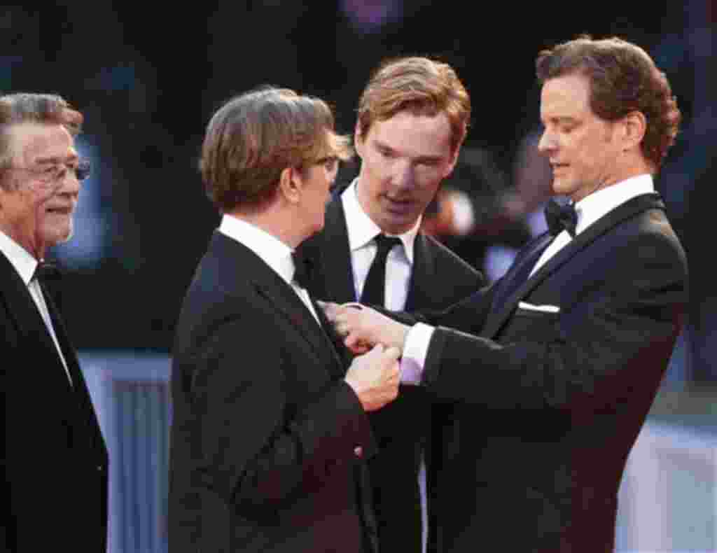 Los actores británicos, Colin Firth, a la derecha, ayudando a Gary Oldman, con su atuendo, y Benedicto Cumberbatch, segundo desde la derecha, y John Hurt mirando, llegan para el estreno de la película 'Tinker, Tailor, Soldier, Spy', en la edición 68 del F
