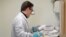 FILE - A pharmacist in Seattle opens a package taken from a freezer that contains a potential vaccine for COVID-19, on the first day of a first-stage safety study clinical trial of the vaccine, March 16, 2020.