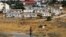 A young Jewish settler rides a bicycle in front of the West Bank settlement of Susiya June 24, 2012.