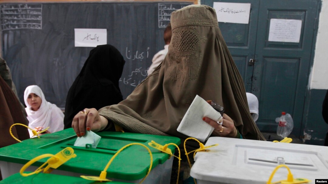 A woman casts her ballot at a polling station in Peshawar May 11, 2013.