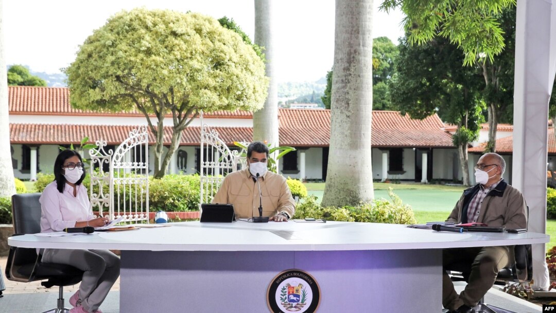 El presidente venezolano, Nicolás Maduro (C), habla junto a la vicepresidenta Delcy Rodríguez (I) y el ministro de Salud Carlos Alvarado durante un anuncio televisado en el Palacio Presidencial de Miraflores, el 6 de septiembre de 2020 en Caracas.
