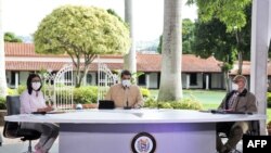 El presidente venezolano, Nicolás Maduro (C), habla junto a la vicepresidenta Delcy Rodríguez (I) y el ministro de Salud Carlos Alvarado durante un anuncio televisado en el Palacio Presidencial de Miraflores, el 6 de septiembre de 2020 en Caracas.