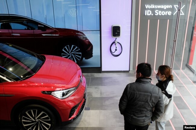 FILE - People check a Volkswagen ID.4 X electric vehicle inside an ID. Store X showroom of SAIC Volkswagen in Chengdu, China on January 10, 2021. (REUTERS/Yilei Sun/File Photo)