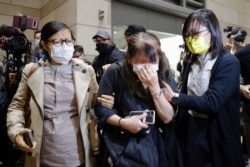 A supporter of pro-democracy activists cries after 15 of 47 activists charged with subversion are granted bail at West Kowloon Magistrates Court in Hong Kong, March 4, 2021. Later, the 15 were remanded to custody after justice officials appealed.
