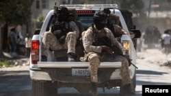 FILE - Armed Haitian National Police officers escort the convoy of the three officers killed by armed gangs after the funeral ceremony at the National Police Academy, in Port-au-Prince, Haiti Jan. 31,2023. 