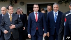 FILE - In this Wednesday, Nov. 25, 2015, file photo, Cyprus President Nicos Anastasiades, left, Turkish Cypriot leader Mustafa Akinci, right, and U.N. envoy Espen Barth Eide, center, leave after their meeting at the U.N.-controlled abandoned Nicosia airport in the divided island of Cyprus.