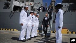 Ukrainian Prime Minister Arseniy Yatsenyuk, center, leaves the USS Donald Cook, the Navy's newest missile cruiser, and passes by the guard of honor in Odessa, Ukraine, Sept. 1, 2015.