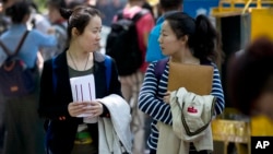 FILE: The Communist Party’s attack on demonstrations centered on Tiananmen Square in 1989 is little more than a distant tale to young Chinese, including two photograhed in Beijing on May 7, 2014.