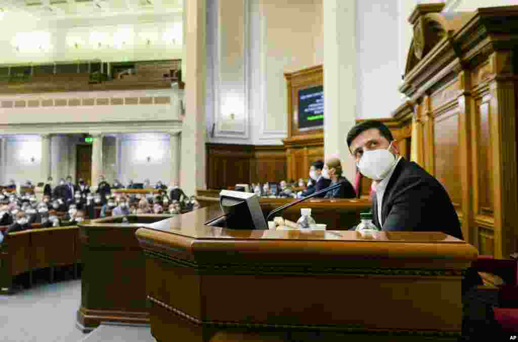 El presidente ucraniano Volodymyr Zelenskiy con una máscara facial para protegerse contra el coronavirus, observa durante una sesión parlamentaria extraordinaria en Kiev, Ucrania.