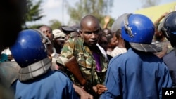 Un soldat force un cordon de police, alors que les manifestants sont une nouvelle fois descendus dans la rue dans le quartier de Musaga, Bujumbura, 11 mai 2015