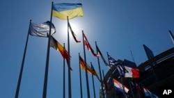 La bandera ucraniana, arriba, ondea con otras banderas europeas frente al Parlamento Europeo, el martes 5 de julio de 2022 en Estrasburgo, este de Francia. (Foto AP/Jean-Francois Badias)