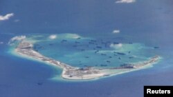 Chinese dredging vessels are purportedly seen in the waters around Mischief Reef in the disputed Spratly Islands in the South China Sea in this still image from video taken by a P-8A Poseidon surveillance aircraft provided by the United States Navy, May 2