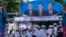Supporters of Prime Minister Hun Sen's Cambodian People's Party dance under portraits of the party leaders, from left, Chea Sim, Hun Sen and Heng Samrin, during an election campaign in Phnom Penh, Cambodia, Thursday, June 27, 2013.