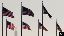 FILE - Bendera Amerika Serikat dengan latar belakang Gedung Capitol Hill, Washington DC. DPR Amerika telah meloloskan anggaran untuk mendanai pemerintah sampai September mendatang.