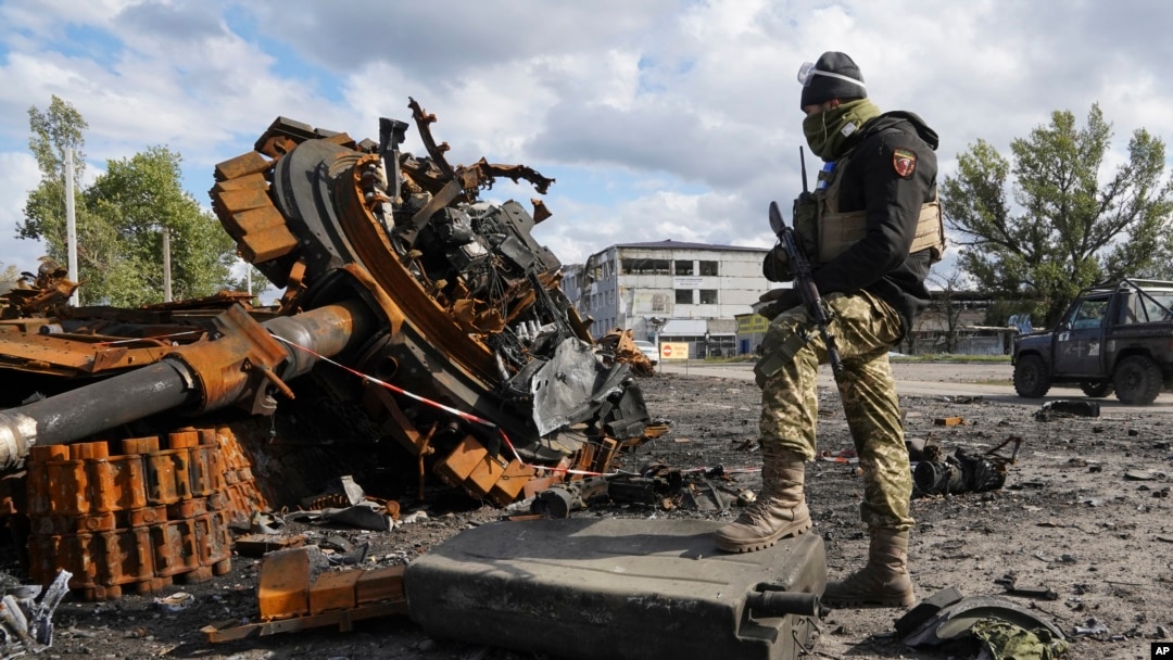 Seorang tentara Ukraina berdiri di dekat tank milik pasukan Rusia yang hancur di wilayah Kharkiv, Ukraina, pada 4 Oktober 2022. (Foto: AP/Andrii Marienko)
