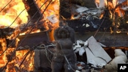 A statue stands outside a burning house in Ein Hod, northern Israel, 04 Dec 2010