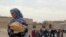 A woman holds bread in Minbij city in the east countryside of Aleppo, Syria, Oct. 18, 2013.