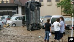 Mobil yang diterjang banjir di Hitoyoshi, Prefektur Kumamoto, Jepang, Minggu, 5 Juli 2020. 