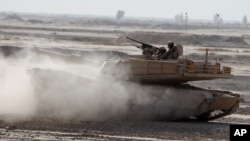 FILE - Iraqi army soldiers in a M1A1 Abrams tank, purchased from the U.S., participate in joint training with U.S. troops at the Besmaya Combat Training Center southeast of Baghdad, Iraq, Aug 24, 2010.