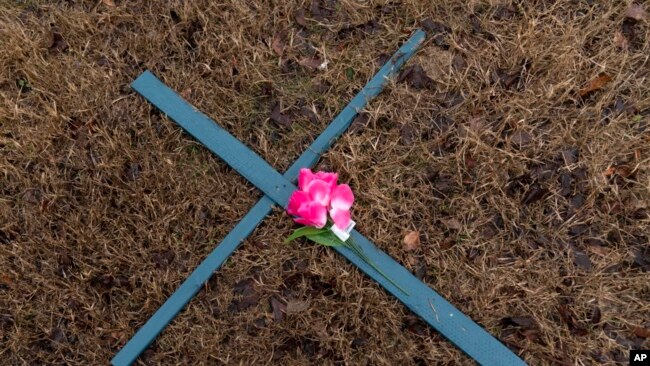 A cross is seen at a makeshift memorial for the victims of the plane crash in the Potomac River, Jan. 31, 2025, in Arlington, Va.