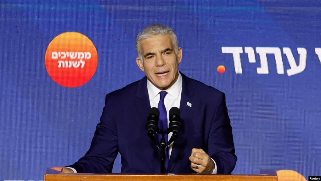 Perdana Menteri Israel dan pemimpin partai Yesh Atid Yair Lapid berbicara kepada para pendukungnya dari panggung di markas partainya selama pemilihan umum Israel di Tel Aviv, Israel, 2 November 2022. (REUTERS/Amir Cohen)