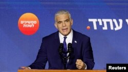 Perdana Menteri Israel dan pemimpin partai Yesh Atid Yair Lapid berbicara kepada para pendukungnya dari panggung di markas partainya selama pemilihan umum Israel di Tel Aviv, Israel, 2 November 2022. (REUTERS/Amir Cohen)