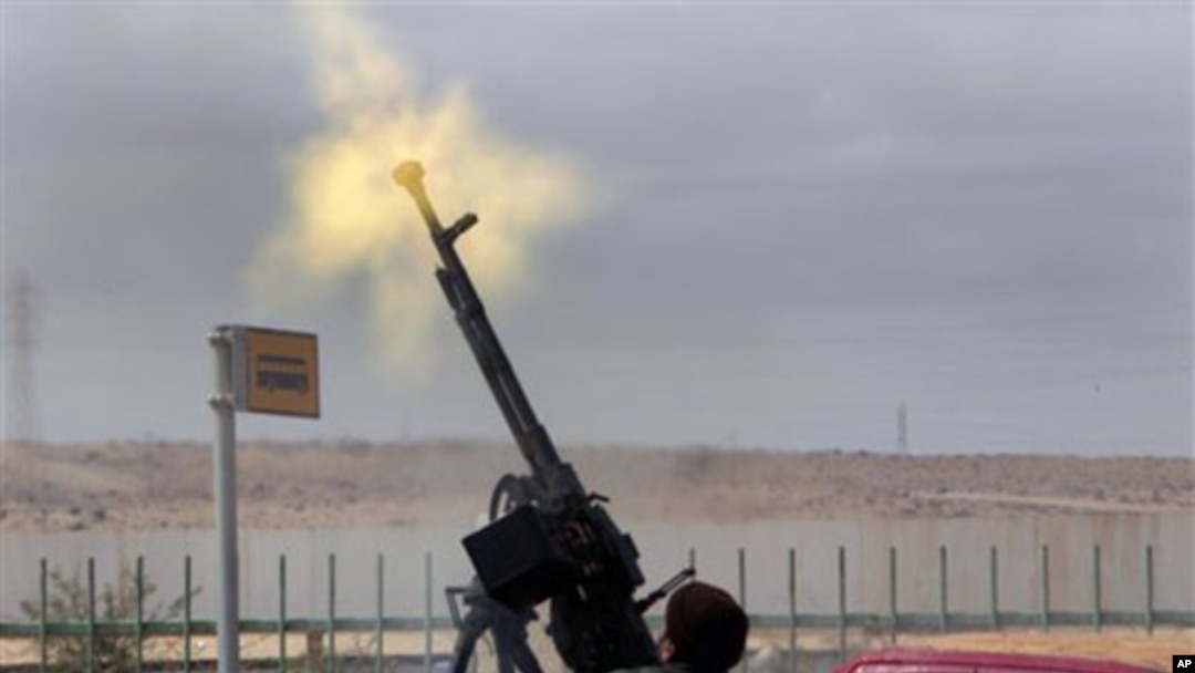 An anti-Gadhafi rebel fires on a government warplane flying overhead in Ras Lanouf, eastern Libya, March 9, 2011