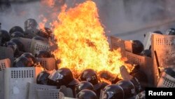 Ajan sekirite Depatman Enteryè a nan Kyèv ap goumen ak yon dife ki te pran aprè manifestan anti-gouvènmantal te lanse koktèl molotov sou lokal la. (Foto: 18 fevriye 2014). 