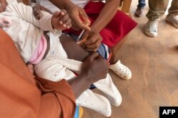 FILE - A health worker administers a malaria vaccine to a baby at a hospital in Soa, Cameroon, on Januey 22, 2024.