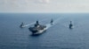Kapal pengawal milik angatan laut Australia yang dilengkapi dengan peluru kendali HMAS Parramatta (FFH 154) (kiri) berlayar bersama kapal perang milik angkatan laut AS dalam sebuah patroli di laut China Selatan pada 18 April 2020. (Foto: U.S. Navy via Reuters)