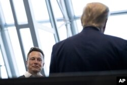 CEO Tesla dan SpaceX Elon Musk berbincang dengan Presiden Donald Trump setelah melihat penerbangan SpaceX menuju Stasiun Luar Angkasa Internasional, di Kennedy Space Center, 30 Mei 2020. (Foto: AP)