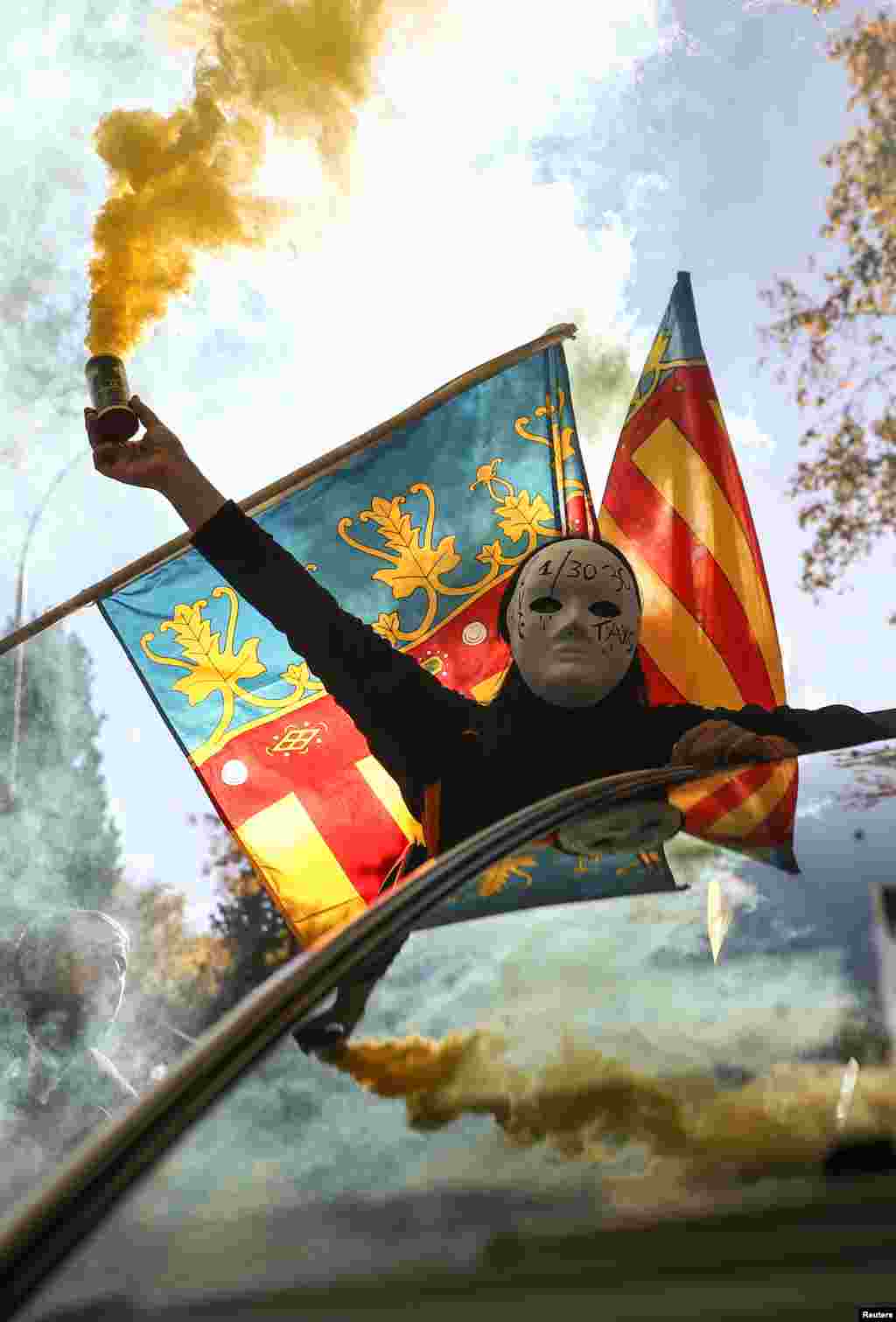 شرکت یک معترض ماسک پوش با نارنجک دودزا در دستش در تظاهرات مادرید اسپانیا بر علیه شرکت های خصوصی مسافربری از جمله اوبر