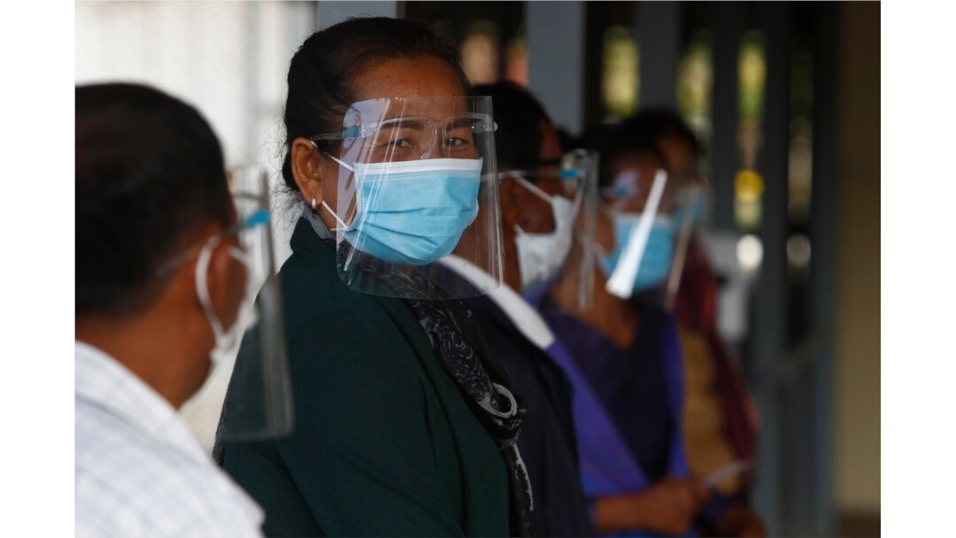 Civic group members wait in queue before getting into the court room of the U.N.-backed war crimes tribunal in Phnom Penh, Cambodia, Aug. 16, 2021.