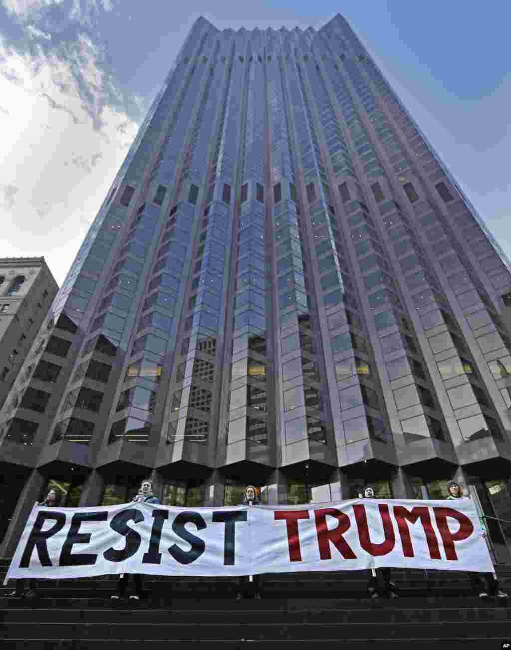 Protestors rally at the entrance of 555 California St., the only partially Trump-owned building in San Francisco, on Friday, Jan. 20, 2017. Protests against the inauguration of President Donald Trump are underway in California. Demonstrators gathered in the rain Friday at San Francisco&#39;s Civic Center Plaza and across the bay in Oakland at the Ronald Dellums Federal Building