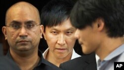 FILE - City Harvest Church founder Kong Hee, center, is surrounded by supporters as he leaves the Subordinate Courts Wednesday, June 27, 2012 in Singapore.