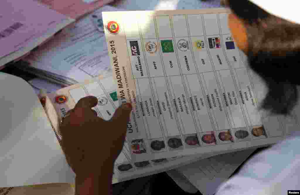 A Tanzanian electoral official holds a ballot paper at a polling station during the presidential and parliamentary election in Ubungo ward in the Kinondoni district of Dar es Salaam, October 25, 2015. 