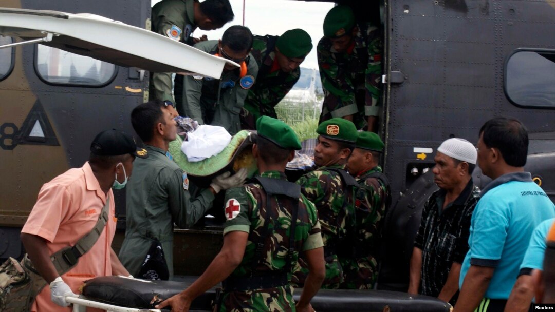 Para prajurit mengeluarkan jenasah prajurit korban serangan kelompok sipil bersenjata, setibanya di bandara Sentani, Papua (22/2/2013)