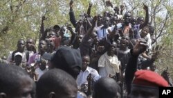 Les partisans du président sénégalais Abdoulaye Wade applaudissent devant le bureau de vote où il devait voter (AP) 