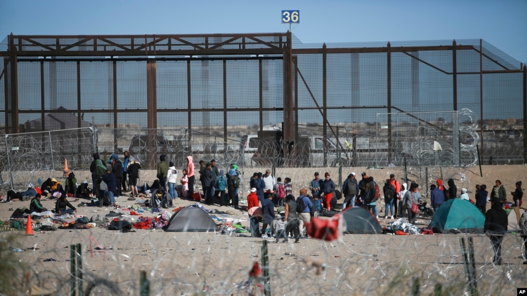Migrantes hacen fila en el muro fronterizo de Estados Unidos después de ser detenidos por las autoridades de inmigración estadounidenses, visto desde Ciudad Juárez, México, el 27 de diciembre de 2023. 