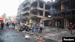 People gather at the site of a suicide car bomb in the Karrada shopping area, in Baghdad, Iraq July 3, 2016.